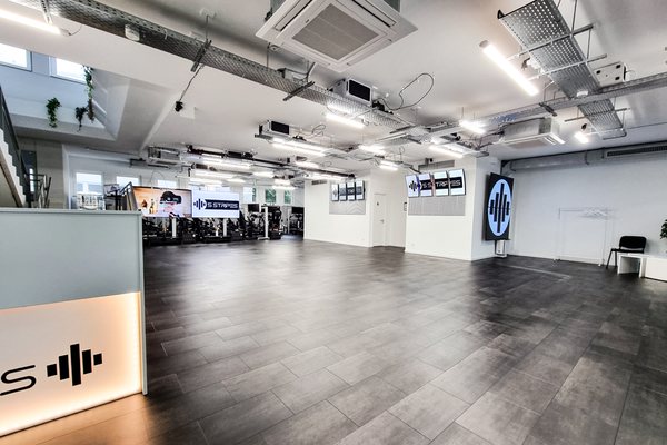 5 STRIPES Lounge: offene Fläche mit Bar und Rennsimulatoren im Hintergrund